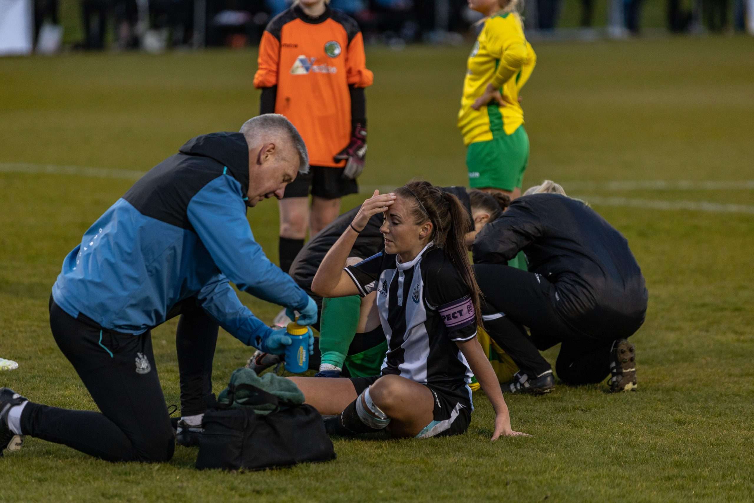 A female football player who has suffered a head impact.