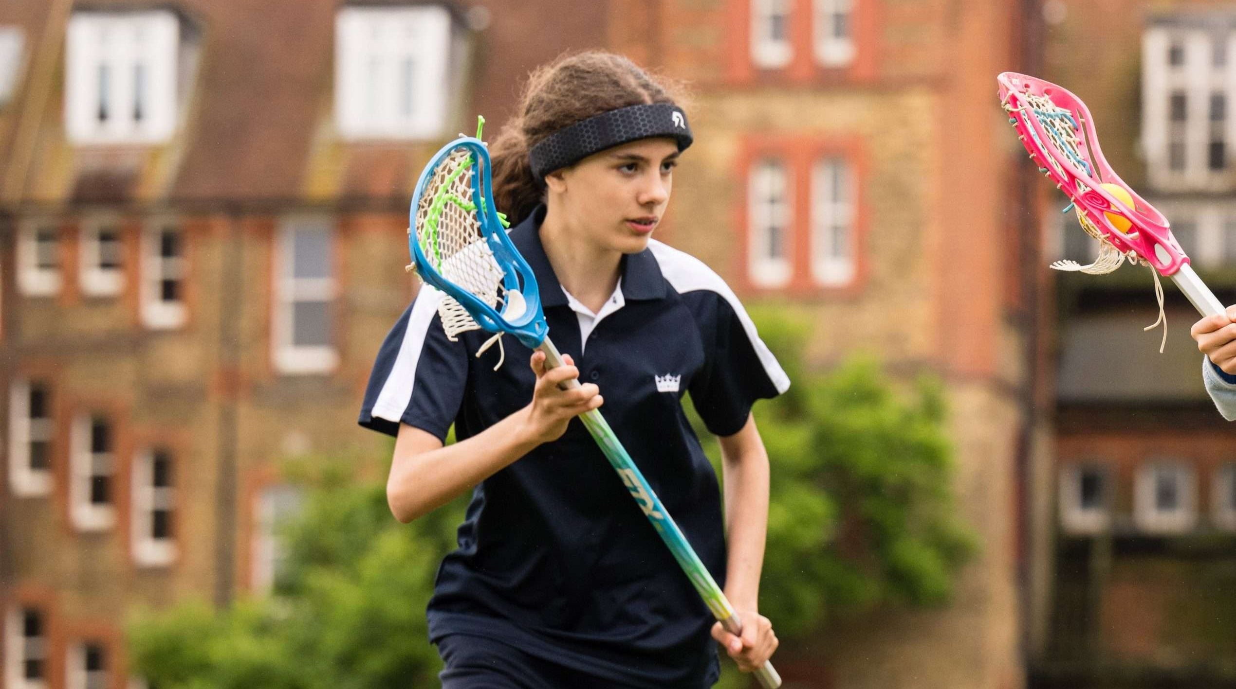 A female youth Lacrosse player wearing Rezon Halos® concussion protection.