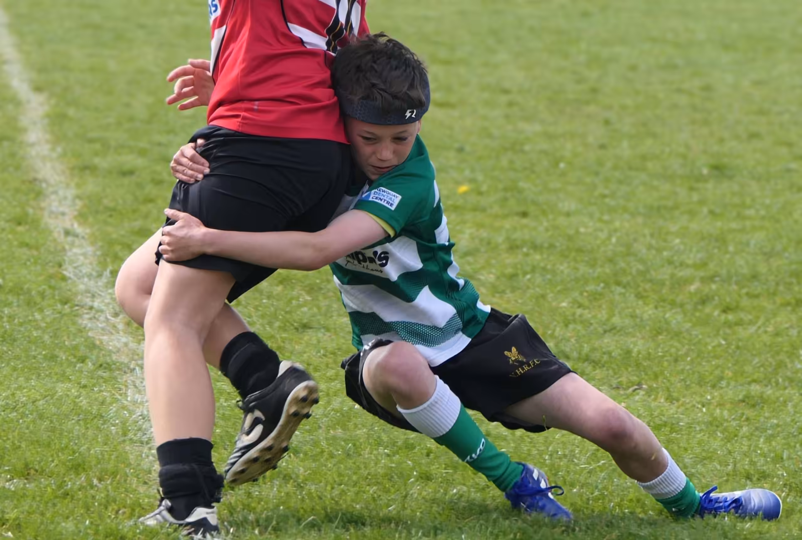 A youth rugby player wearing a Rezon Halos® rugby headguard.