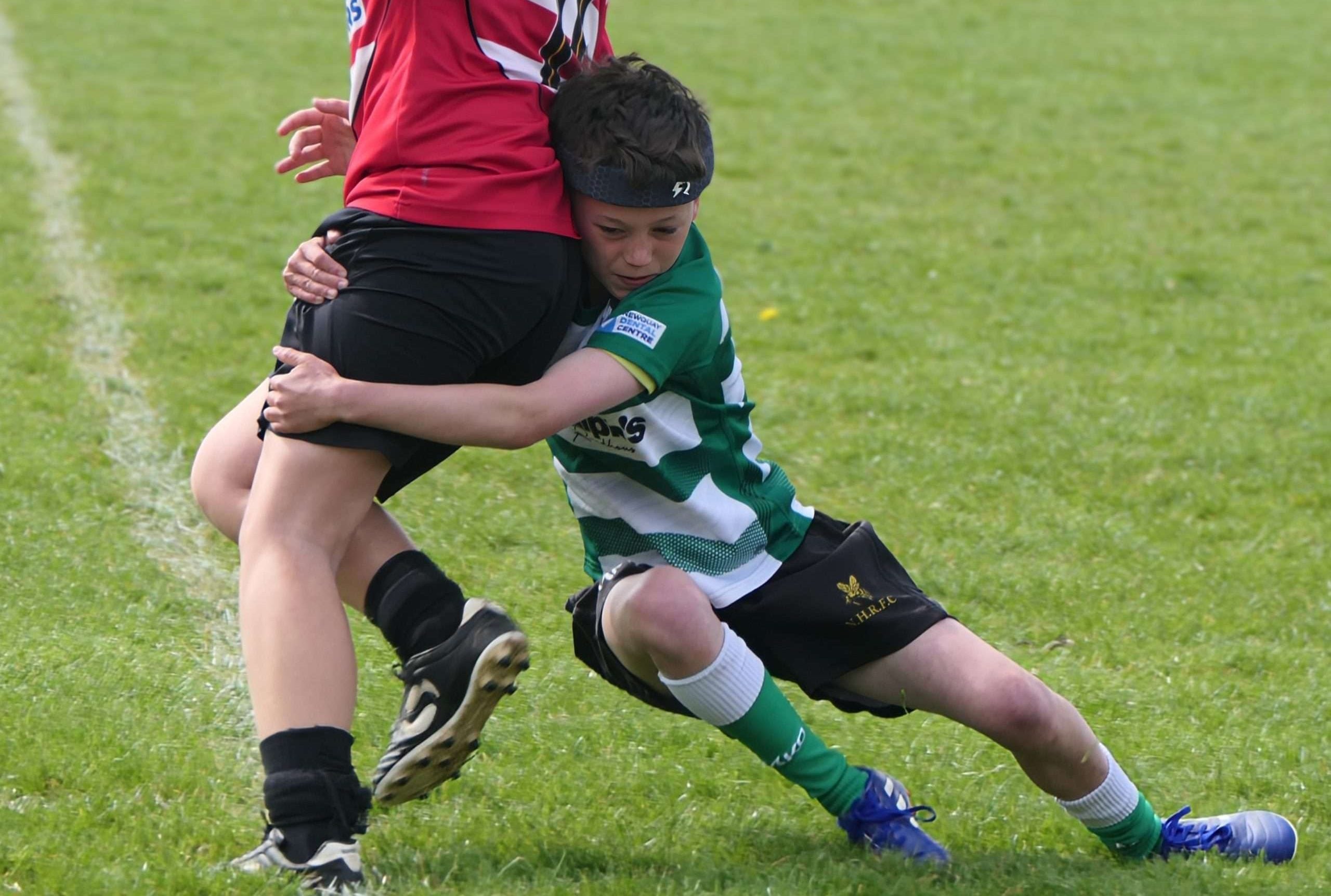 A youth rugby player wearing a Rezon Halos® rugby headguard.
