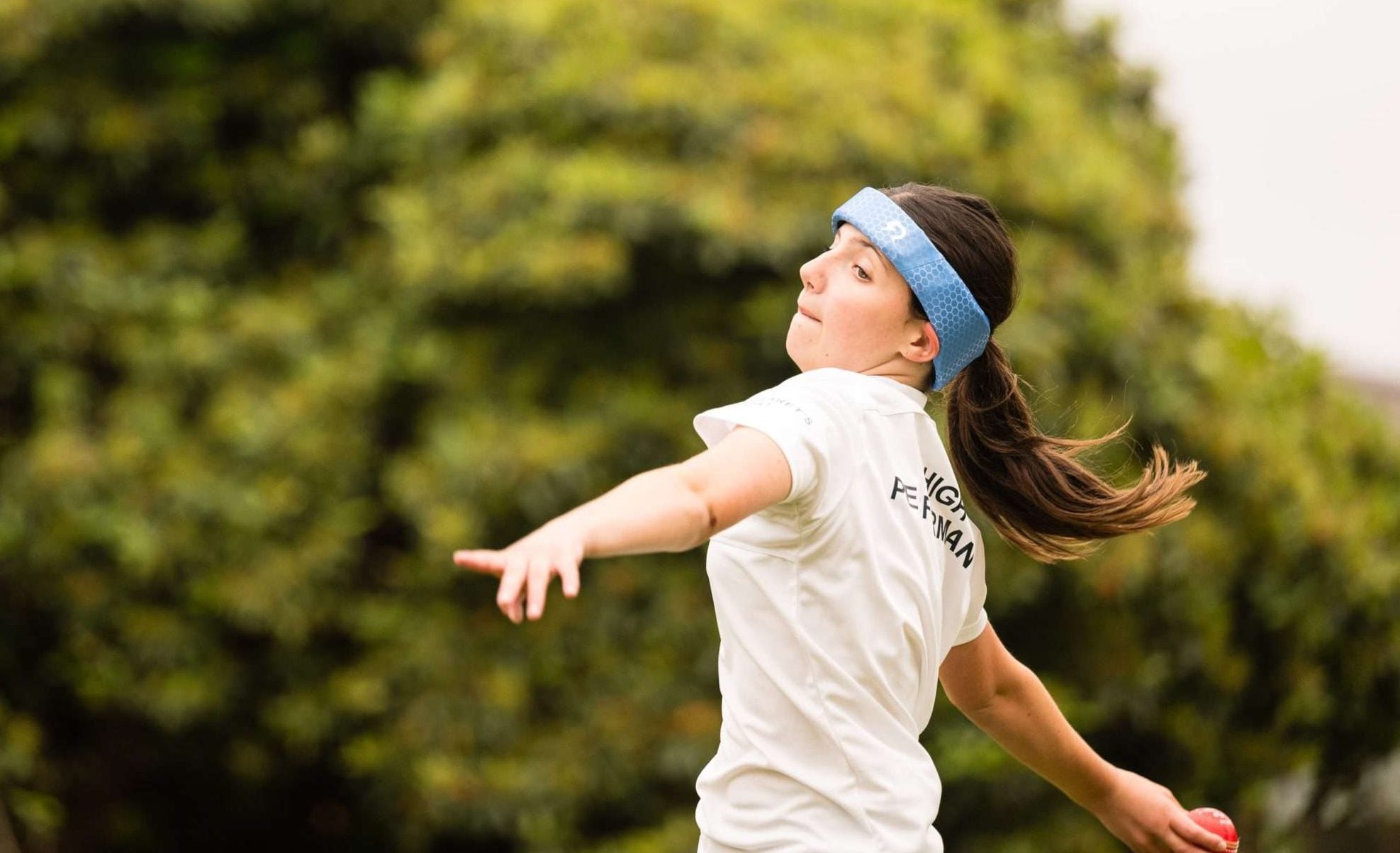 A cricket bowler wearing Rezon Halos® brain protection.